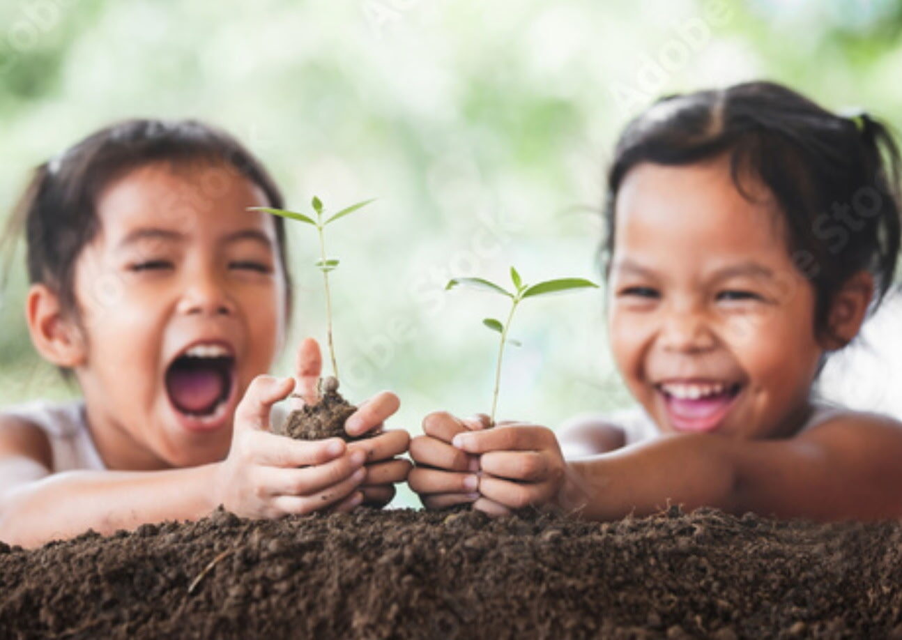 Two kids laughing while planting