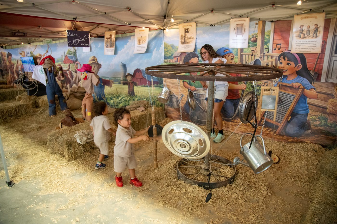 Kids playing hanging pots and washboards at the music station